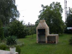 a stone oven in the grass in a yard at Holiday home in Balatonmariafürdo 19232 in Balatonkeresztúr
