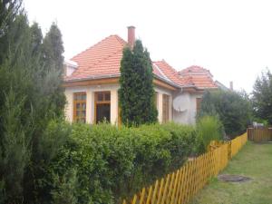 a house with a yellow fence in front of it at Holiday home in Balatonmariafürdo 19232 in Balatonkeresztúr