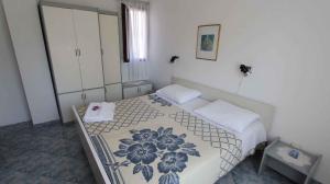 a bedroom with a bed with a floral bedspread at Apartment Malinska,Krk, Primorje-Gorski Kotar 10 in Vantačići