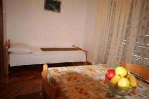 ein Zimmer mit einem Tisch und einer Obstschale darauf in der Unterkunft One-Bedroom Apartment Silo near Sea 1 in Šilo