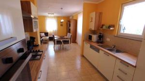 a kitchen with a sink and a table in a room at Apartment Malinska, Krk 14 in Sveti Vid-Miholjice