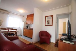 a living room with a red couch and a kitchen at Apartment in Silo/Insel Krk 14597 in Šilo