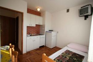 a small kitchen with a sink and a refrigerator at One-Bedroom Apartment Silo near Sea 6 in Šilo