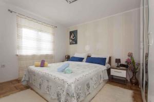 a bedroom with a large white bed with blue pillows at Studio in Crikvenica 5257 in Dramalj