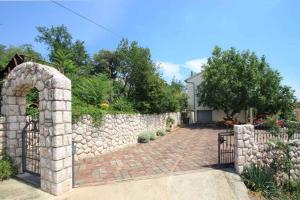 a stone fence with an arch in front of a driveway at Studio in Crikvenica 5257 in Dramalj