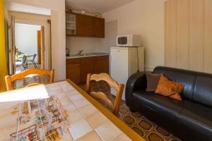 One-Bedroom Apartment Crikvenica 30 في كريكفينيسا: غرفة معيشة مع أريكة جلدية سوداء وطاولة