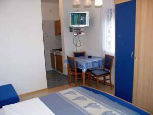 a room with a blue table and chairs and a television at Studio Crikvenica 8 in Dramalj