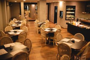 a restaurant with tables and chairs and a counter at Geneviee Palace Hotel in Ponta Grossa