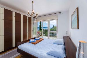a bedroom with a large bed and a large window at Apartment in Crikvenica 5215 in Dramalj