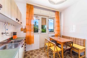 a kitchen with a table and a sink and a window at Apartment in Crikvenica 5215 in Dramalj