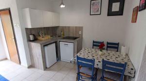 a kitchen with a table and a kitchen with a table and chairs at Apartments in Malinska/Insel Krk 14421 in Sveti Anton