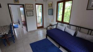 a bedroom with a bed with blue sheets and windows at Apartments in Malinska/Insel Krk 14421 in Sveti Anton