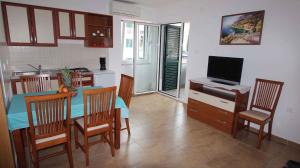a kitchen and dining room with a table and a television at Apartment in Malinska 30 in Vantačići