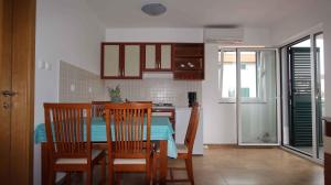 a kitchen and dining room with a table and chairs at Apartment in Malinska 30 in Vantačići