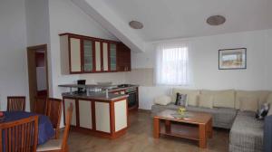 een keuken en een woonkamer met een bank en een tafel bij Apartment Malinska, Krk 2 in Vantačići