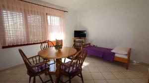 a room with a table and chairs and a bed at Apartment Malinska, Krk 19 in Malinska