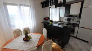 a kitchen with a table with a pineapple on it at Apartment in Malinska 12 in Sveti Vid-Miholjice