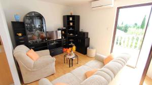 a living room with two couches and a table at Apartment in Malinska 12 in Sveti Vid-Miholjice