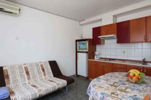 a kitchen with a bed and a table with fruit on it at Apartment in Silo/Insel Krk 13441 in Šilo