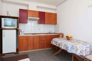 a kitchen with a table and a tv and a refrigerator at Apartment in Silo/Insel Krk 13441 in Šilo