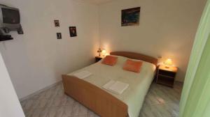 a bedroom with a bed with two orange pillows on it at Apartment Porat 1 in Porat