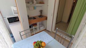 a kitchen with a table with a bowl of fruit on it at Apartment Porat 1 in Porat