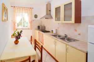 a kitchen with a sink and a table with a table sidx sidx at Apartment Vinkuran 6 in Vinkuran +14 photos