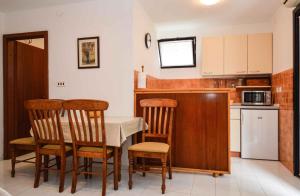 a kitchen with a table and chairs and a microwave at Apartment Pjescana Uvala/Istrien 11126 in Vintijan