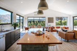 a kitchen and living room with a table with wine glasses at Minaret Ridge - Family Friendly - Sleeps 8 - Mountain Views - Close to Lake in Wanaka