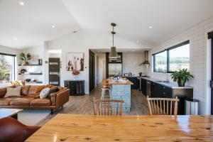 a kitchen and living room with a couch and a table at Minaret Ridge - Family Friendly - Sleeps 8 - Mountain Views - Close to Lake in Wanaka +7 photos