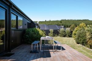 a patio with two chairs and a table at Minaret Ridge - Family Friendly - Sleeps 8 - Mountain Views - Close to Lake in Wanaka