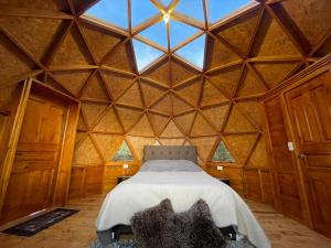 a bedroom with a bed in a large wooden room at GLAMCAPTOUR in Guatavita