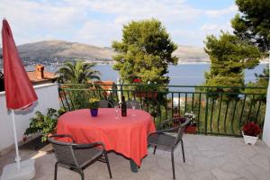 a table on a balcony with a view of the water at Apartment Okrug Donji 6 in Okrug Gornji