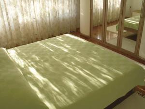 zielone łóżko w pokoju z lustrem w obiekcie Apartment in Zadar/Zadar Riviera 7970 w mieście Smirić