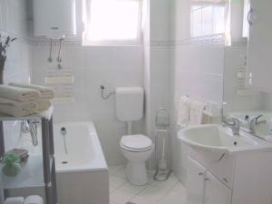 biała łazienka z toaletą i umywalką w obiekcie Apartment in Zadar/Zadar Riviera 7970 w mieście Smirić