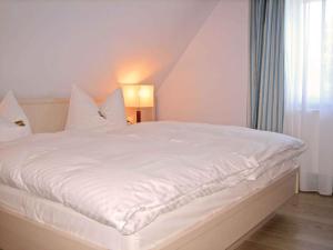 a white bed in a room with a window at Holiday home in Prerow (Ostseebad) 2650 in Prerow