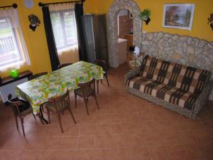 un salon avec une table, des chaises et un canapé dans l'établissement Holiday home in Balatonmariafürdo 19426, à Balatonmáriafürdő