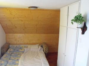 un lit dans une chambre avec un mur en bois dans l'établissement Holiday home in Balatonmariafürdo 19426, à Balatonmáriafürdő
