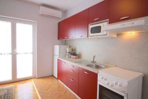a small kitchen with red cabinets and a sink at Apartment in Porec/Istrien 10303 in Poreč
