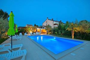 a swimming pool with chairs and a house at Apartment in Porec/Istrien 10303 in Poreč