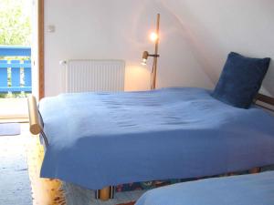 un letto blu in una stanza con finestra di Apartment in Dierhagen (Ostseebad) 2646 a Dändorf
