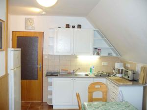 een kleine keuken met witte kasten en een tafel bij Apartment in Rokytnice nad Jizerou 2471 in Rokytnice nad Jizerou