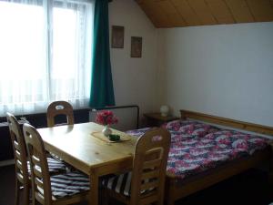 ロキトニツェ・ナト・イゼロウにあるApartment in Rokytnice nad Jizerou 2471のテーブル、椅子、ベッドが備わる客室です。