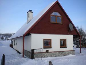 VlciceにあるHoliday home in Vlcice u Trutnova 2323の雪の赤い屋根の家