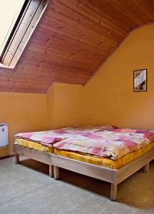 a bed in a room with a wooden ceiling at Holiday home in Cerna v Posumavi 1908 in Černá v Pošumaví +15 photos