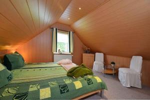 a bedroom with a bed and two chairs in a room at Apartment Bergen auf Rugen 1 in Bergen auf Rügen