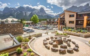 a town with a parking lot with mountains in the background at Beautiful Peak Vista - 2BR w Stunning Mt Views in Canmore