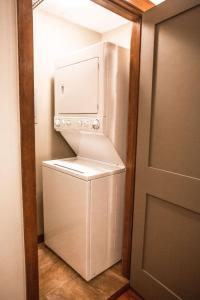 a white refrigerator with its door open in a kitchen at Beautiful Peak Vista - 2BR w Stunning Mt Views in Canmore