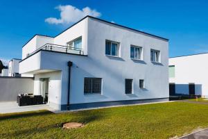 Biały dom z trawnikiem przed nim w obiekcie LEON Apartment NEU! Gemütlichkeit an erster Stelle w Linzu