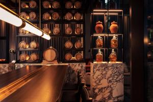 a bar with jars and vases on the wall at Next Hotel Melbourne in Melbourne